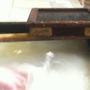 European papermaking. Hogging the vat (i.e. agitating the fiber and water to evenly distribute the fibers).